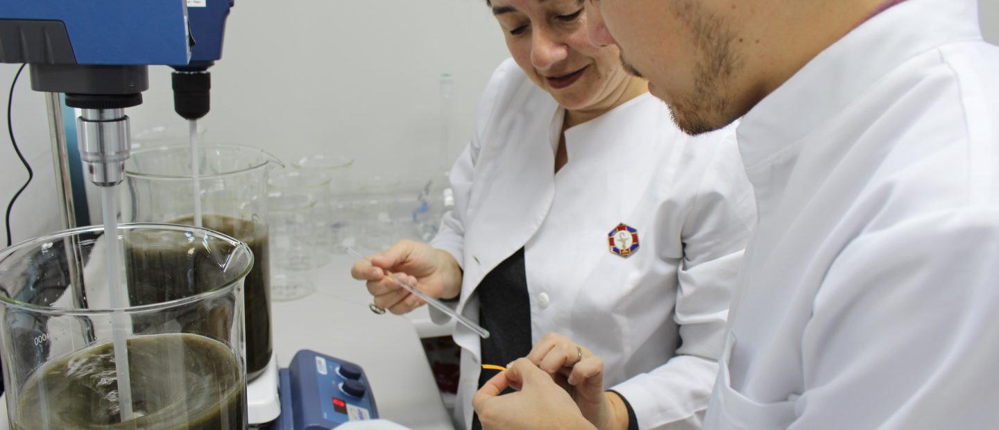 Una científica y un científico realizando un experimento.