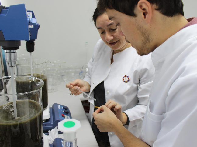 Una científica y un científico realizando un experimento.