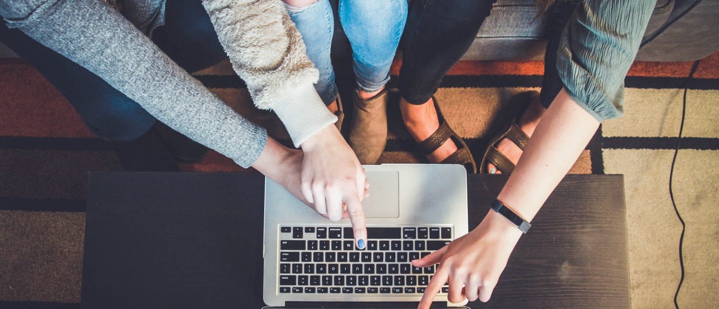 Personas apuntando a un computador