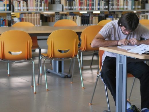 Estudiante leyendo un libro en la biblioteca
